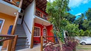 una casa roja y blanca con escaleras y un coche en Apartamento Vivendas do Serrano, en Lençóis