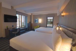 a hotel room with two beds and a television at Hotel Edison Times Square in New York