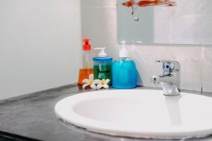 um lavatório de casa de banho com duas garrafas de sabão e um espelho em Kubu Indah Homestay Sanur em Sanur