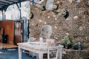 Habitación con mesa y pared de piedra. en Kubu Indah Homestay Sanur, en Sanur