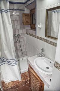 a bathroom with a sink and a shower with a shower curtain at Casa De La Fuente in Bubión