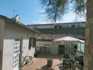 a patio with a table and an umbrella at Appartamenti Santa Chiara in Assisi