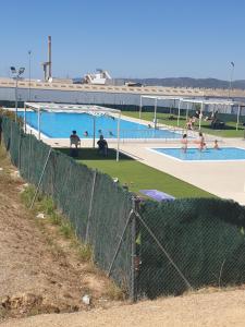 a swimming pool with people in the water at Appartement 6 Personnes - L'arboc in Arbós