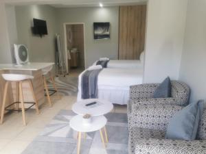 Habitación de hotel con cama, silla y mesa en Comfort e Casa en Kempton Park