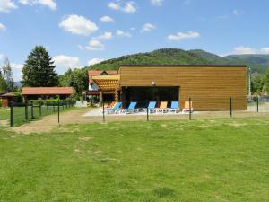 a building with a group of chairs in a field at Flower Camping les Bouleaux in Ranspach