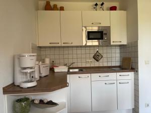 uma cozinha com armários brancos e comodidades para preparar café em Ferienwohnung Störblick Schwerin em Raben Steinfeld