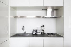 a white kitchen with a sink and a stove at Perfectly located 2BD near Times Square with Gym in New York