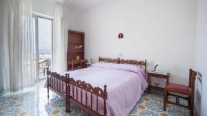 1 dormitorio con cama y ventana grande en Villa Luna di Miele, en Isquia