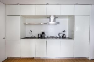 a kitchen with white cabinets and a sink at Beautiful 2BD Apartment near Times Square in New York