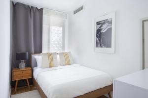 a white bedroom with a bed and a window at Beautiful 2BD Apartment near Times Square in New York