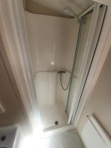 um chuveiro com uma porta de vidro na casa de banho em Fantasy Island King Fisher 8Berth 401 em Ingoldmells