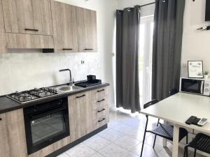 a kitchen with a stove and a sink and a table at Apartments Ana & Ita in Novalja