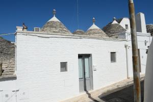 un edificio bianco con tetto piastrellato di Trullo A Casedd ad Alberobello