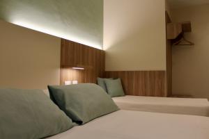 a bedroom with two beds with green pillows at Albergo Degli Amici in Monterosso al Mare