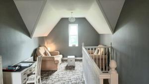 a baby room with a crib and a chair at Yeats Lodge in Drumcliff