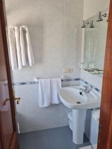 a white bathroom with a sink and a toilet at AS VIÑAS in O Grove