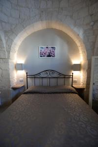 una camera con un letto in una parete in pietra di Trullo A Casedd ad Alberobello