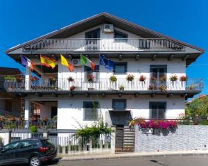 a white building with flags on its balconies and a car at B&B Alfio Tomaselli in Nicolosi