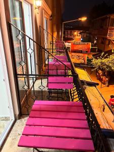 a group of pink benches sitting on a balcony at Ada Antik 2 in Adalar