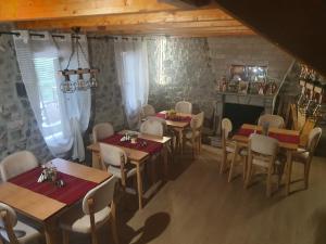 a dining room with tables and chairs and a fireplace at Villa Davisol in Theth