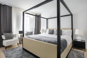 a bedroom with a black and white canopy bed and a chair at Modern 2BD in Midtown with Washer and Dryer in-unit in New York