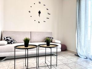 a living room with a couch and a clock on the wall at Apartments Ana & Ita in Novalja