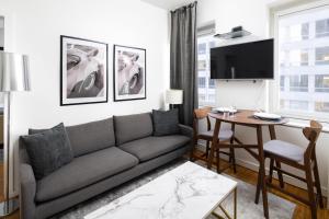 ein Wohnzimmer mit einem Sofa und einem Tisch in der Unterkunft Gorgeous One-Bedroom on 35th floor in Midtown in New York