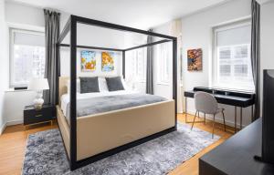 um quarto com uma cama de dossel e uma secretária em Gorgeous One-Bedroom on 35th floor in Midtown em Nova York