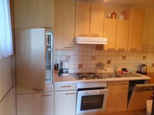 a kitchen with white appliances and wooden cabinets at Apartments Rauter in Annenheim