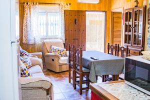 Una sala de estar con una mesa y sillas y un televisor. en Apartamento Félix Romero, en Castril