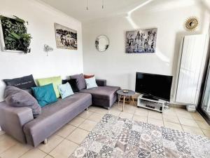 een woonkamer met een bank en een flatscreen-tv bij T2 au calme-vue mer et baie de Collioure-Garage in Collioure