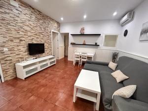 a living room with a couch and a tv at Chalet Empul El Béjar in Chiclana de la Frontera
