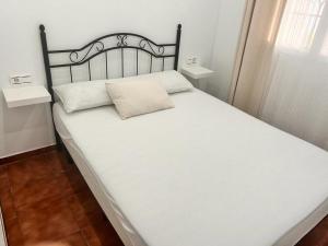 a large white bed with a black headboard in a room at Chalet Empul El Béjar in Chiclana de la Frontera