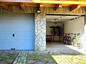 a garage with a blue garage door and two bikes at Apartamenty 4 Góry in Szczyrk