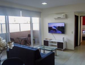 ein Wohnzimmer mit einem Sofa und einem TV an der Wand in der Unterkunft Comodo apartamento en Boedo in Buenos Aires