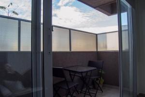 einen Balkon mit einem Tisch und Stühlen sowie einem Fenster in der Unterkunft Comodo apartamento en Boedo in Buenos Aires
