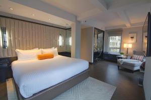 a bedroom with a large bed and a living room at Hotel Edison Times Square in New York