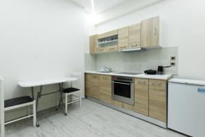 eine Küche mit Holzschränken und einer Arbeitsplatte in der Unterkunft Vila SHAKAJ in Sarandë