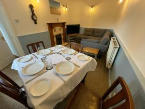 a table with plates on it in a living room at Glanywerydd Cottage in Barmouth