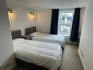 a hotel room with two beds and a window at Glanywerydd Cottage in Barmouth