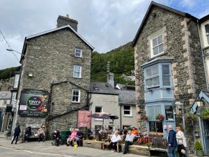un gruppo di persone sedute fuori da un edificio di Glanywerydd Cottage a Barmouth
