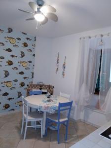 una sala da pranzo con tavolo, sedie e parete di pesce di Casa Iosi a Sirolo a Sirolo