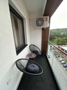 2 sillas y una mesa en el balcón en Matic Apartmani 4 en Trnava