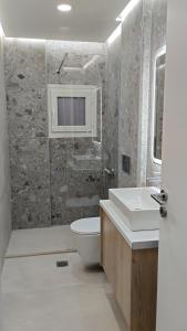 a bathroom with a sink and a toilet at inas apartments 2 in Lefkímmi