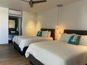 two beds in a hotel room with a room with at The Cove Boutique Hotel Adults Only in Puerto Peñasco