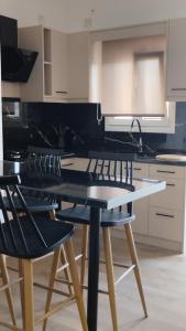 a kitchen with a table and four chairs in it at inas 2 bedroom apartment in Lefkimmi