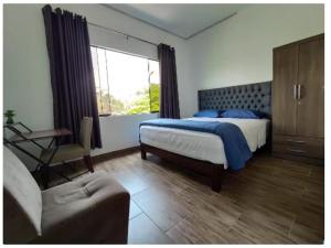 um quarto com uma cama, um sofá e uma janela em Green House em Lima
