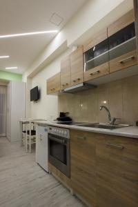 uma cozinha com armários de madeira e um lavatório em Vila SHAKAJ em Sarandë