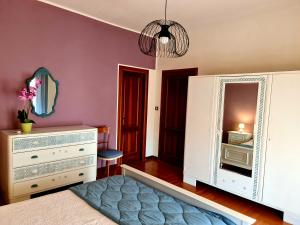 una camera da letto con cassettiera bianca e specchio di V.home ad Abano Terme