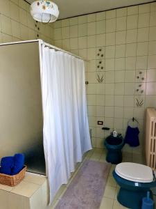 a bathroom with a shower curtain and a toilet at V.home in Abano Terme